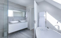 Picture of a newly installed white bathroom with grey tiles by plumbers in Rotherham