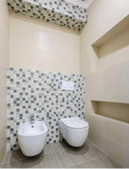 White toiler and bidet fitted onto a chequered tile wall by our bathroom fitters in Rotherham